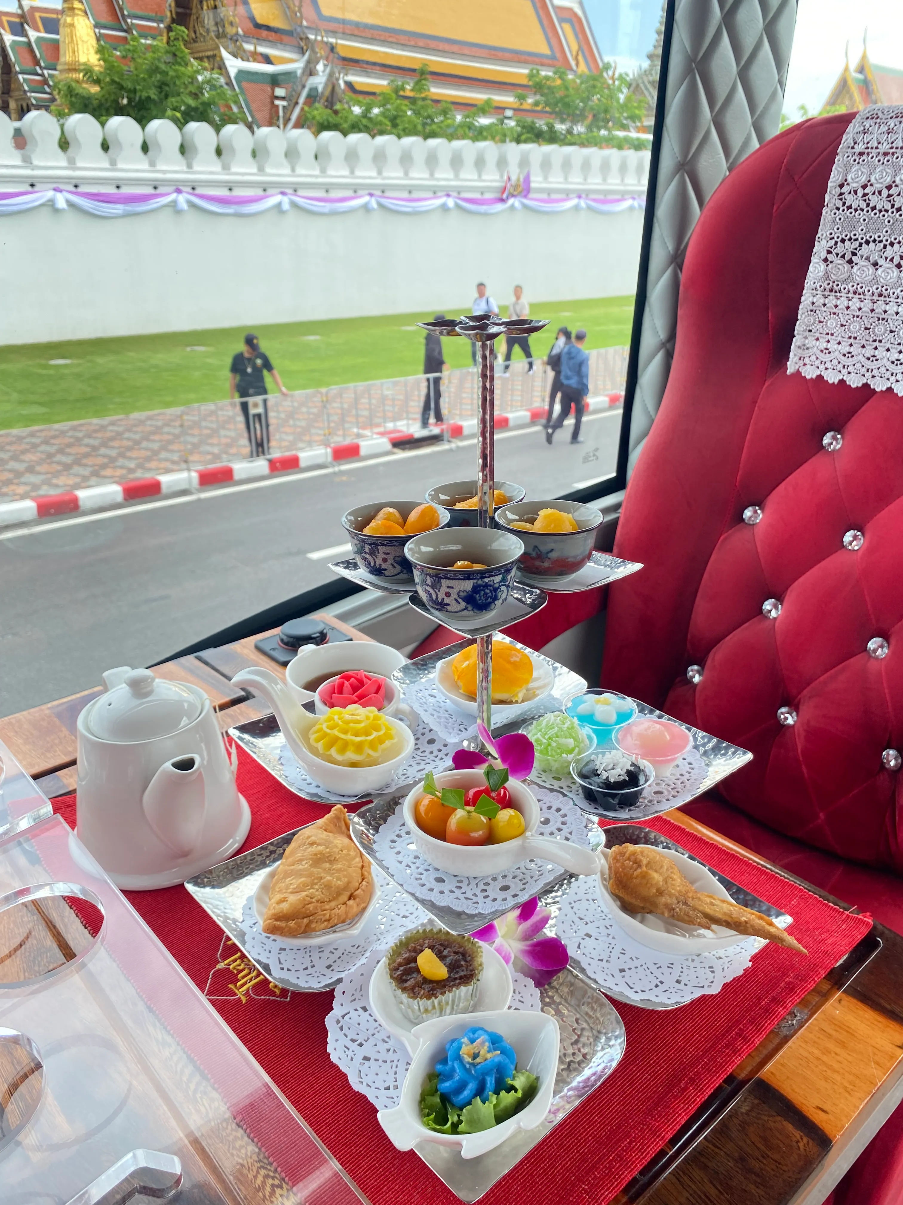 Multiple curry dishes served on white plates with pink garnish and purple orchid flowers