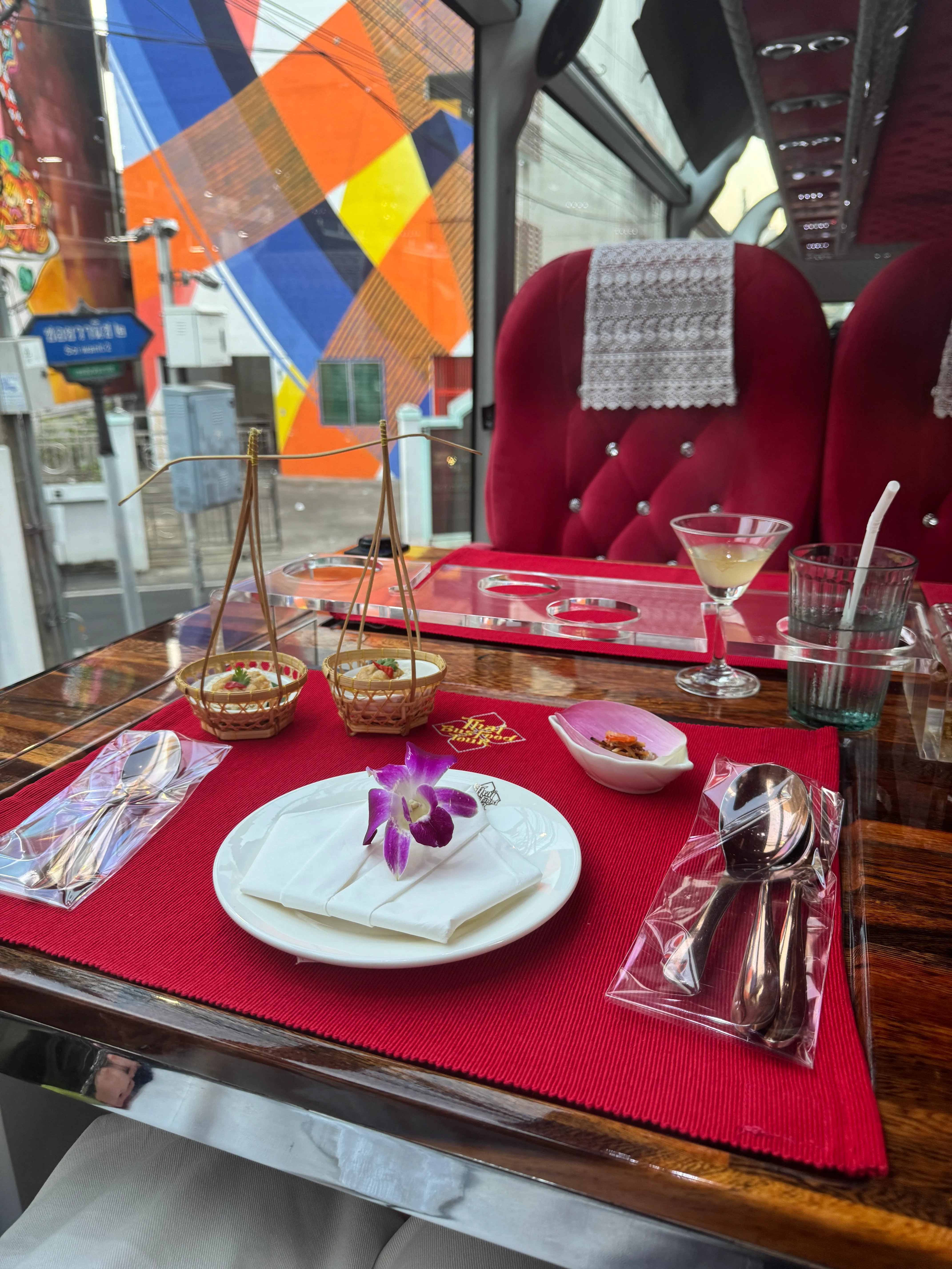 Thai iced tea drink and golden fried pastries served on table inside bus