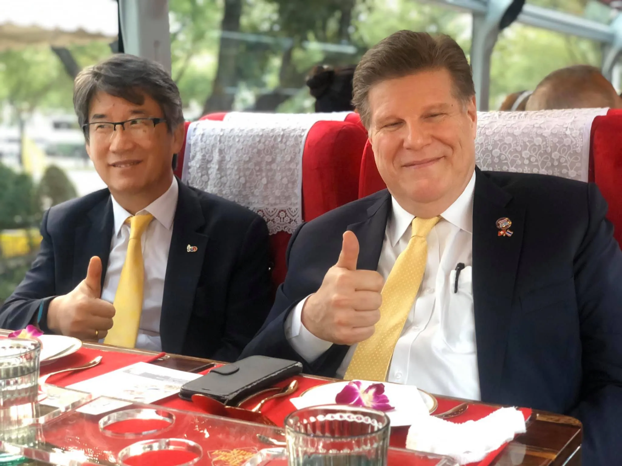 Close-up of hand holding hanging basket with delicate Thai appetizer and flower garnish
