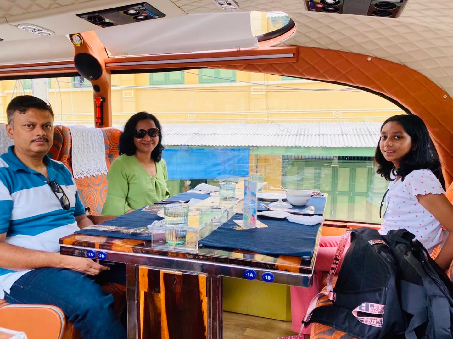 Scenic outdoor table setting with river and traditional Thai architecture in background