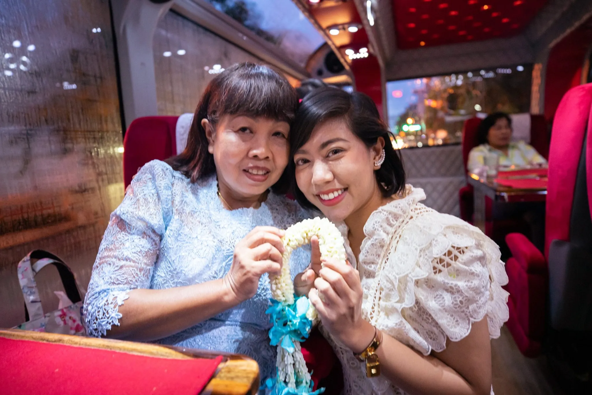 Guests dining and enjoying food inside the tour bus at night with warm ambient lighting