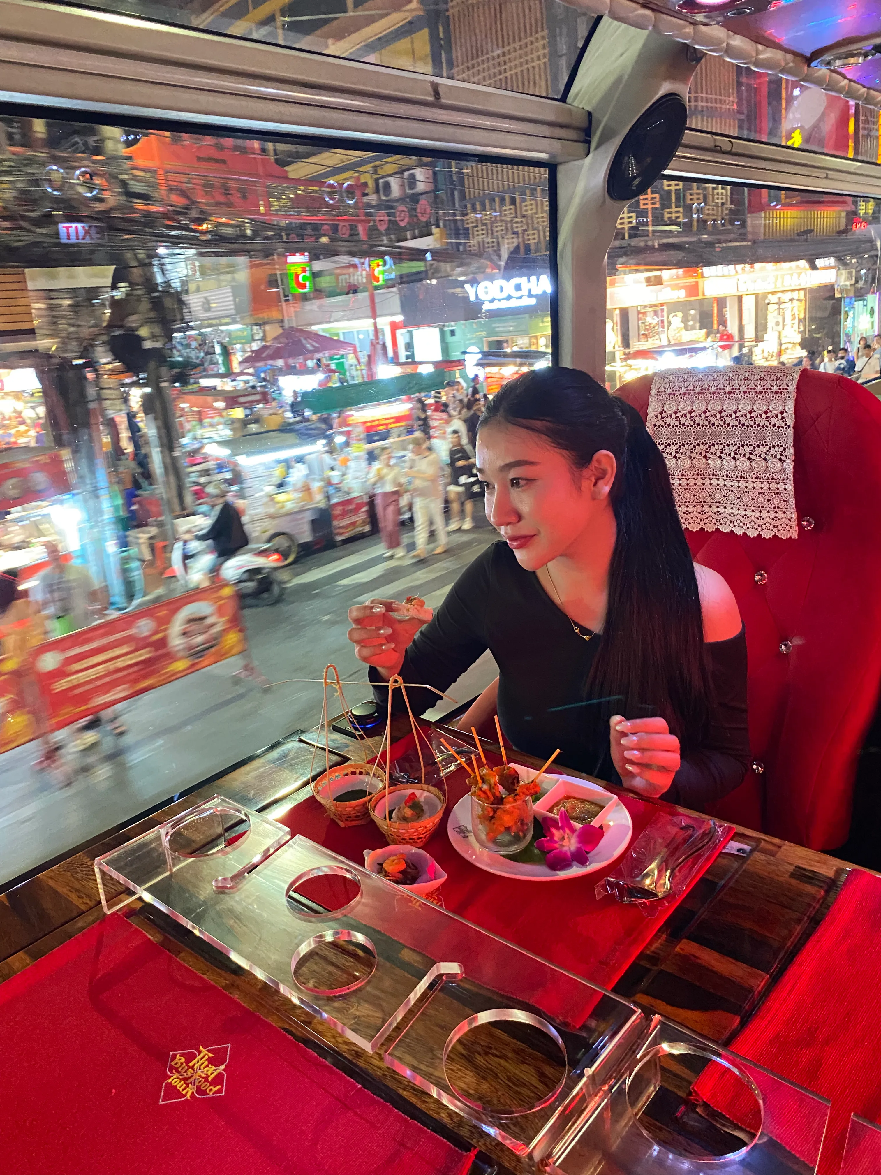 Michelin street food set with wok-fired pad thai served on the Thai Bus Food Tour, with the Giant Swing landmark visible through the window