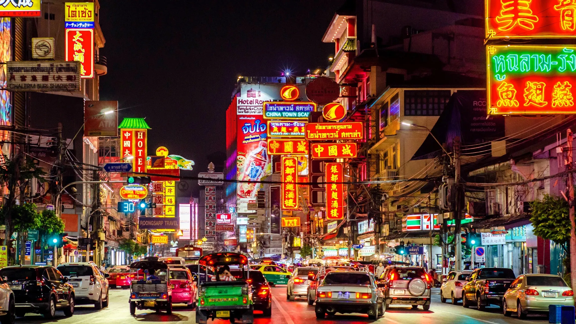 The ceremonial Yaowarat Gate arch lit at night at the entrance to Bangkok's Chinatown, with red lanterns and neon signage behind it