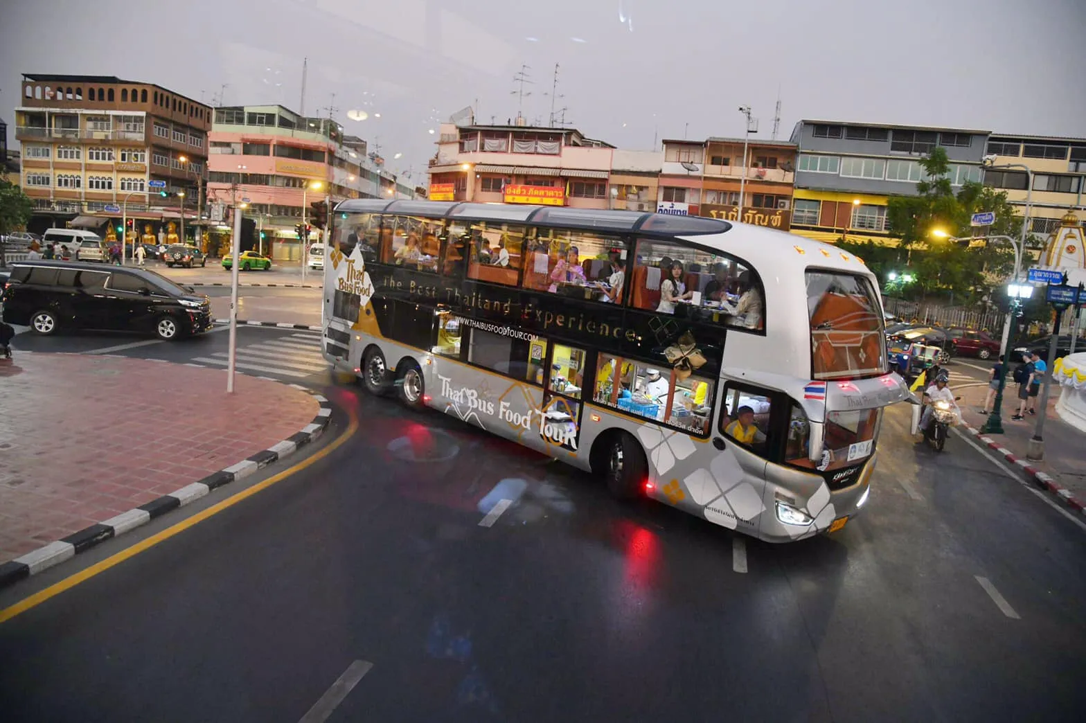 The Thai Bus Food Tour luxury double-decker touring Bangkok's Old Town streets at dusk
