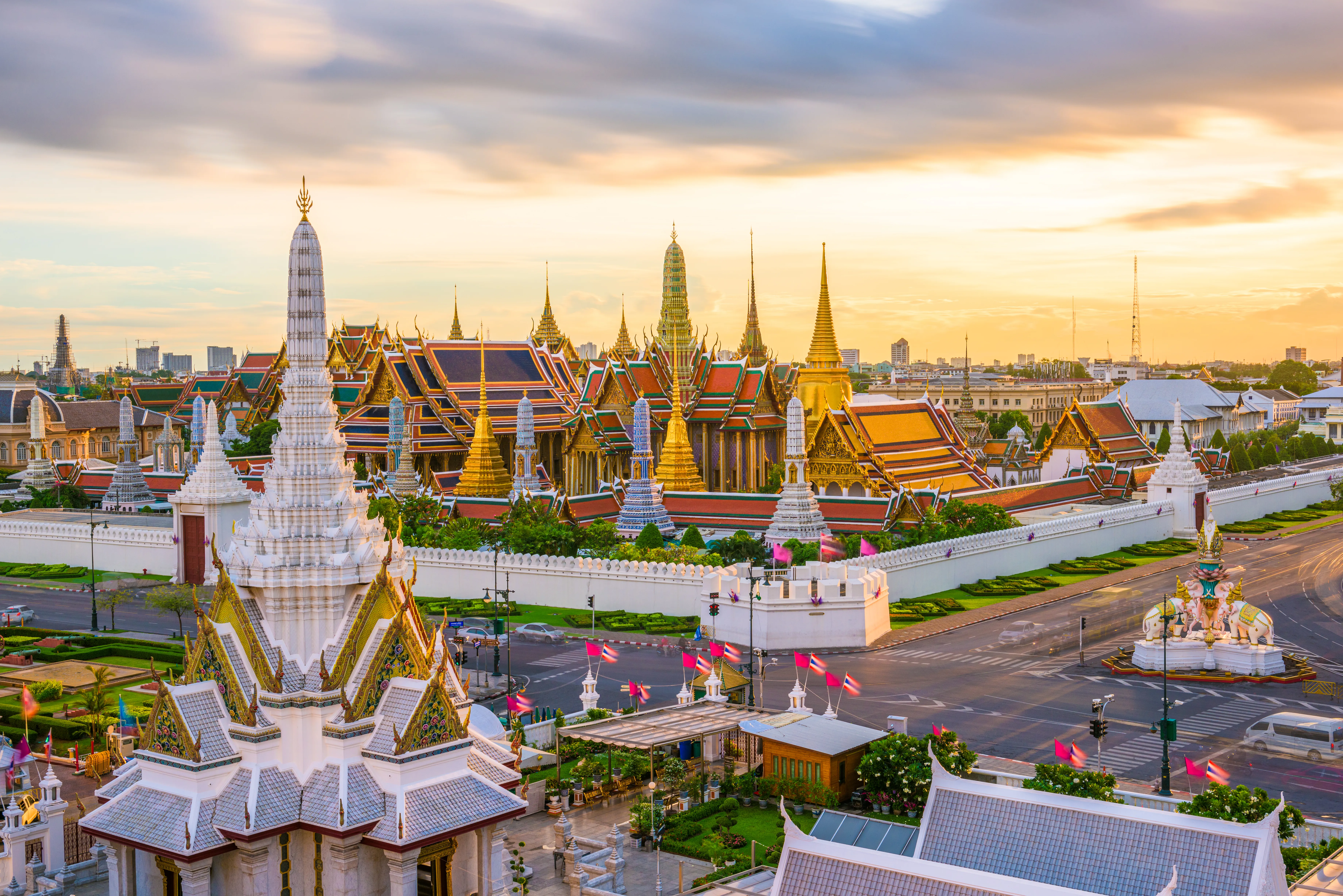 Traveller with a small suitcase boarding the Thai Bus Food Tour double-decker at River City Bangkok, golden temples visible in the evening light